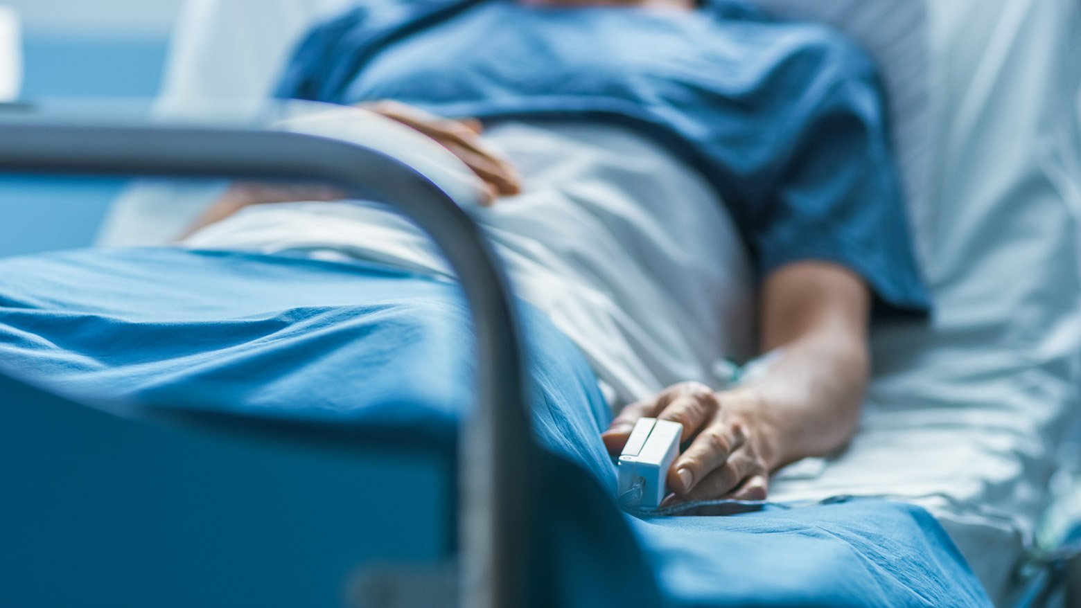Patient lies in a hospital bed